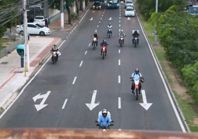 Motocicleta estacionada com nota de IPVA mostrando benefício de 50% para motociclistas de aplicativo em Fortaleza