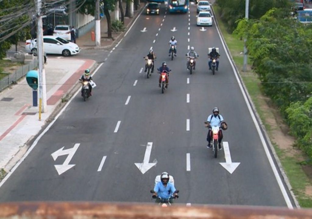 Motocicleta estacionada com nota de IPVA mostrando benefício de 50% para motociclistas de aplicativo em Fortaleza