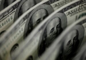 Traders monitoram telas de mercado financeiro enquanto dólar cai e bolsa bate recorde histórico