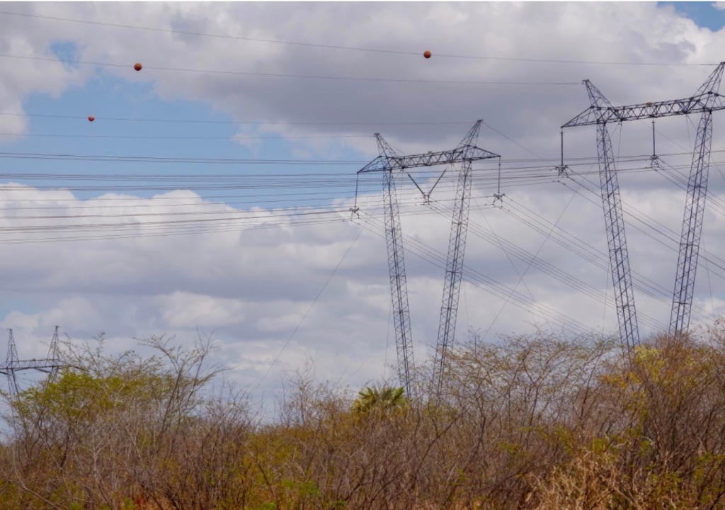 Linhas de transmissão e postes de energia elétrica em região urbana representando reajuste na conta de luz no Nordeste