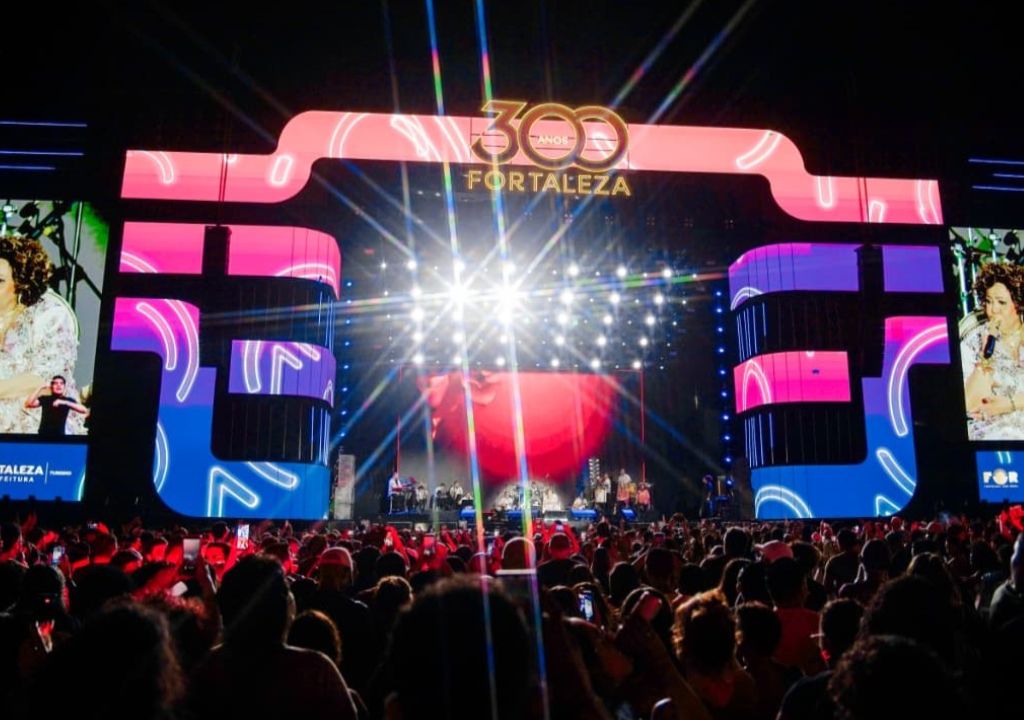 Multidão na Praia de Iracema durante festa dos 300 anos de Fortaleza sob chuva