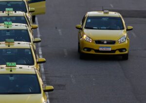 Motorista de aplicativo dirigindo veículo em cidade brasileira