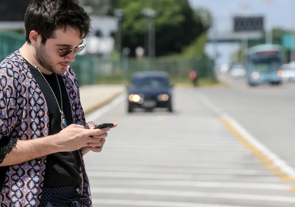 Motociclista parceiro da Uber Moto utiliza aplicativo após mudança no modelo de cobrança em Fortaleza.